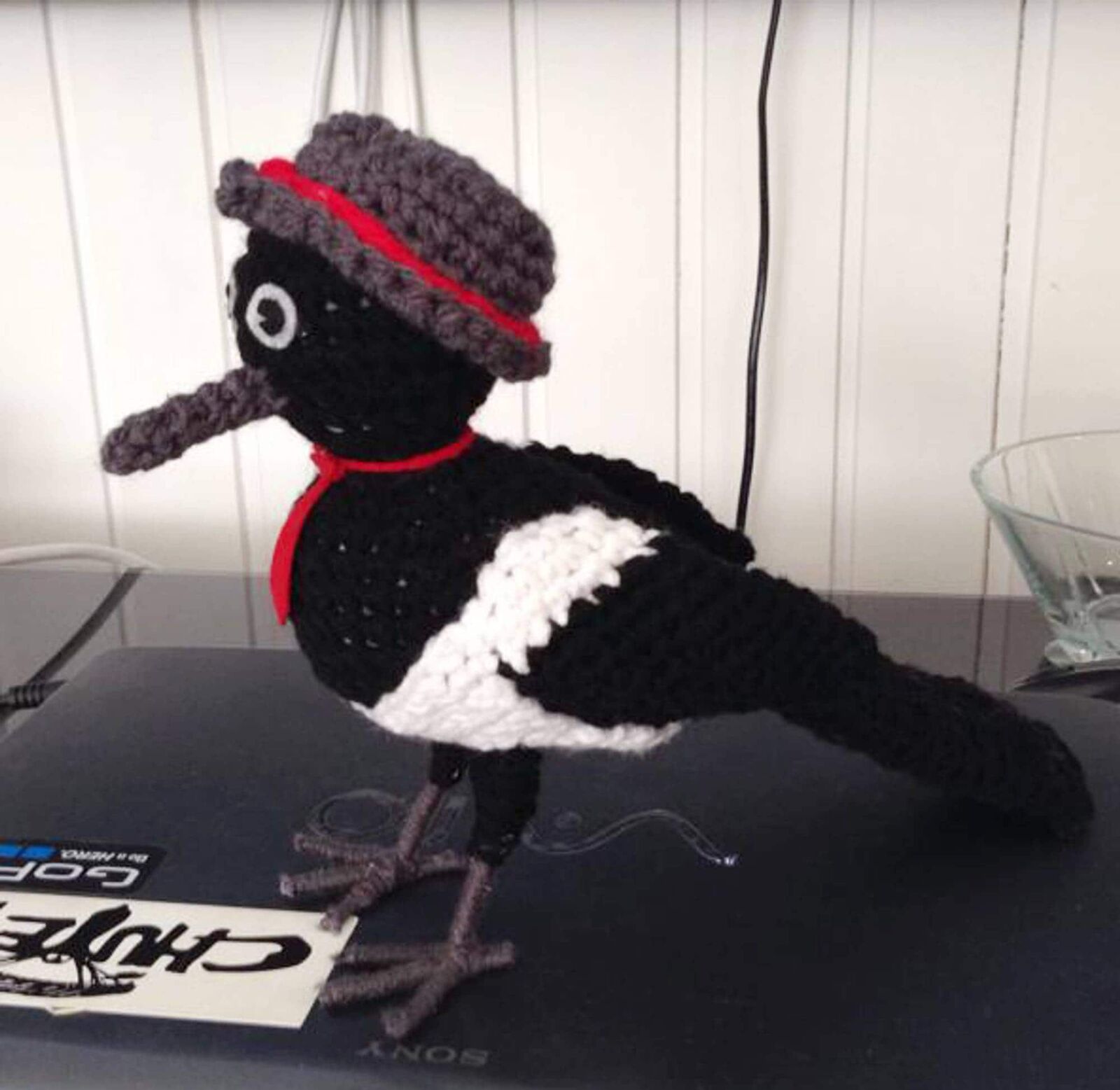 Crocheted magpie with a hat